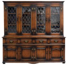 A George II style oak dresser, 20th c, the upper part enclosed by two pairs of leaded glass doors