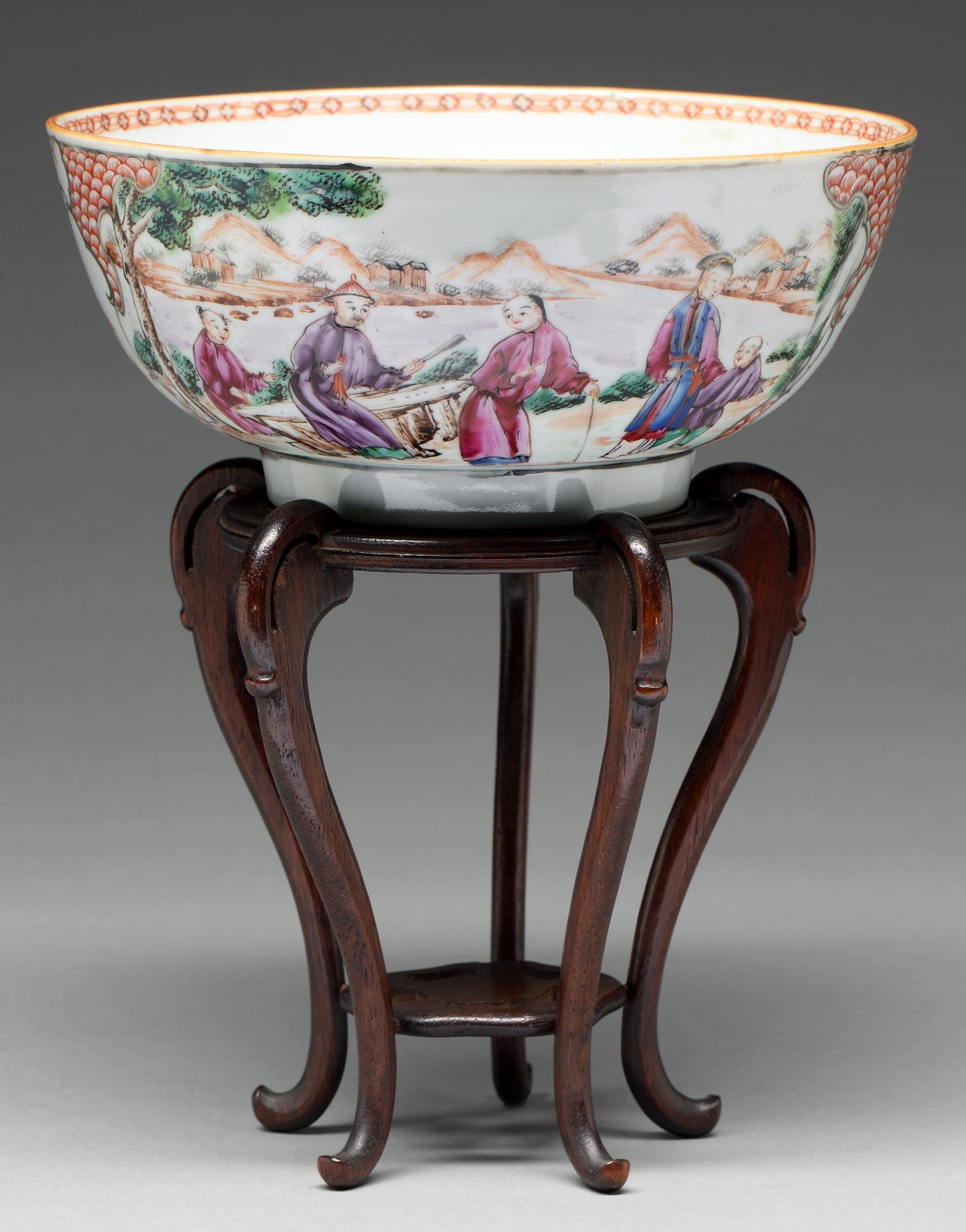 A Chinese famille rose bowl, c1770, painted with two groups of figures by water in a mountainous