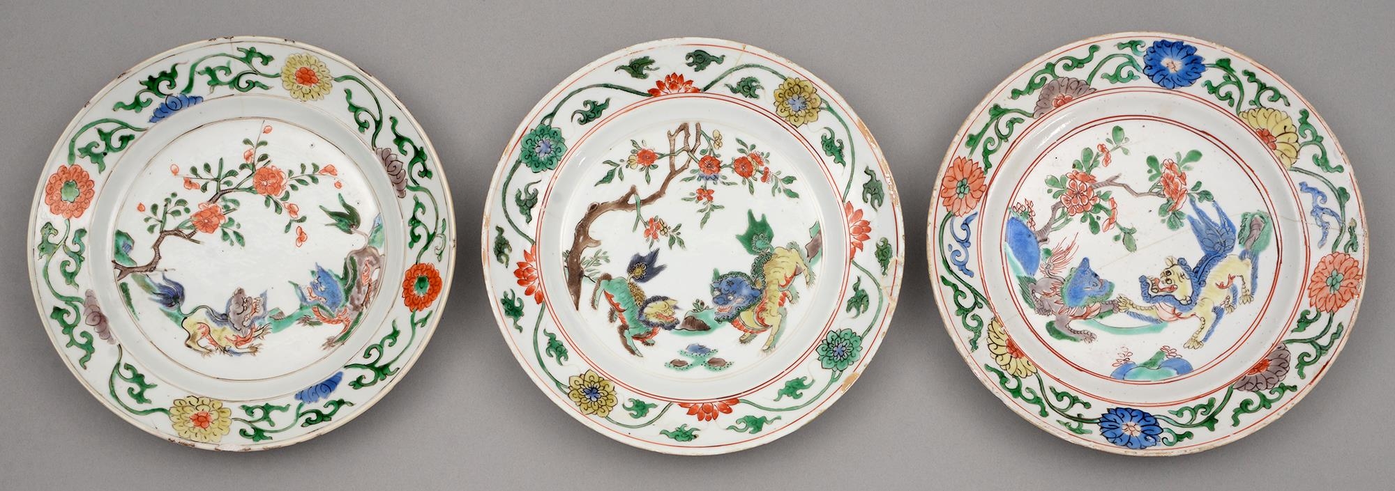 Three Chinese famille verte plates, Kangxi period, enamelled with two dogs of Fo beneath a flowering