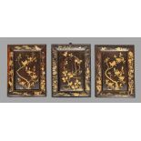 A set of three Japanese lacquered wood panels, Meiji period, decorated in gold lacquer and