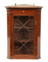 An Edwardian mahogany and line inlaid hanging corner cabinet, with dentil cornice, serpentine