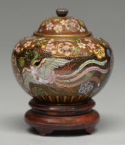 A Japanese cloisonne enamel jar and cover, enamelled with two phoenix beneath overlapping floral