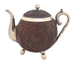 An Indian silver mounted coconut teapot and cover, late 19th c, crisply carved with peacocks and