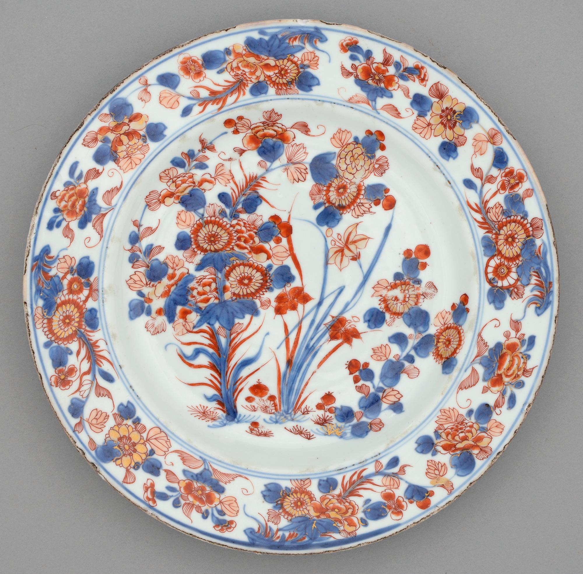 A Chinese Imari plate, 18th c, painted with three clumps of flowering plants bordered by trailing