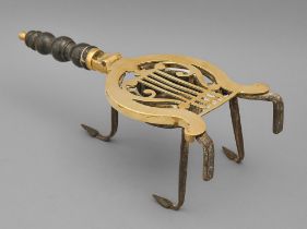 A Victorian brass trivet, the lifting top of lyre shape, on iron frame with well, ebonised handle,