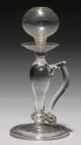 A glass open flame oil lamp, late 18th c, on folded foot, soda metal, 21.5cm h Thumbpiece chipped
