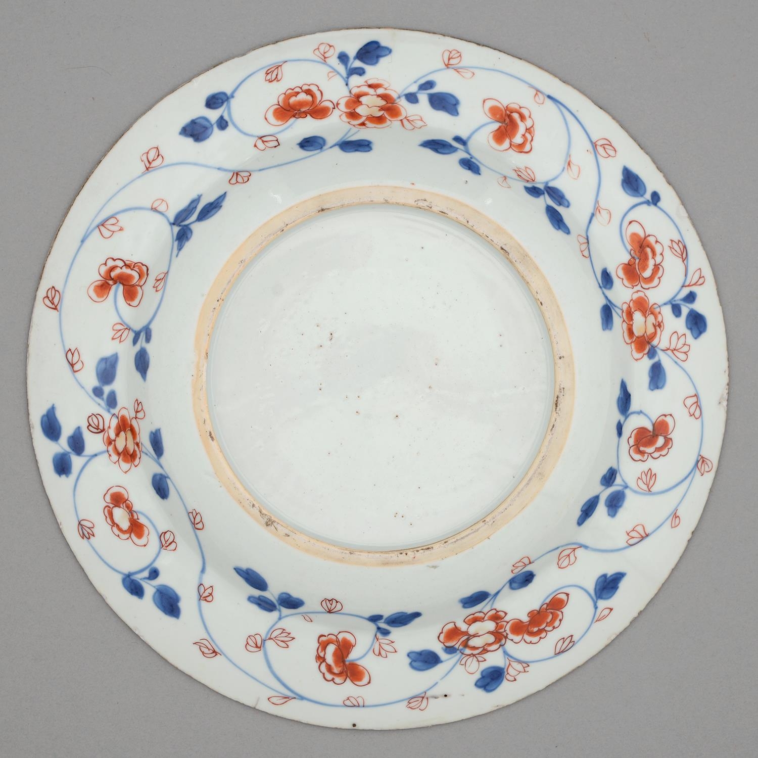 A Chinese Imari plate, 18th c, painted with three clumps of flowering plants bordered by trailing - Image 2 of 2