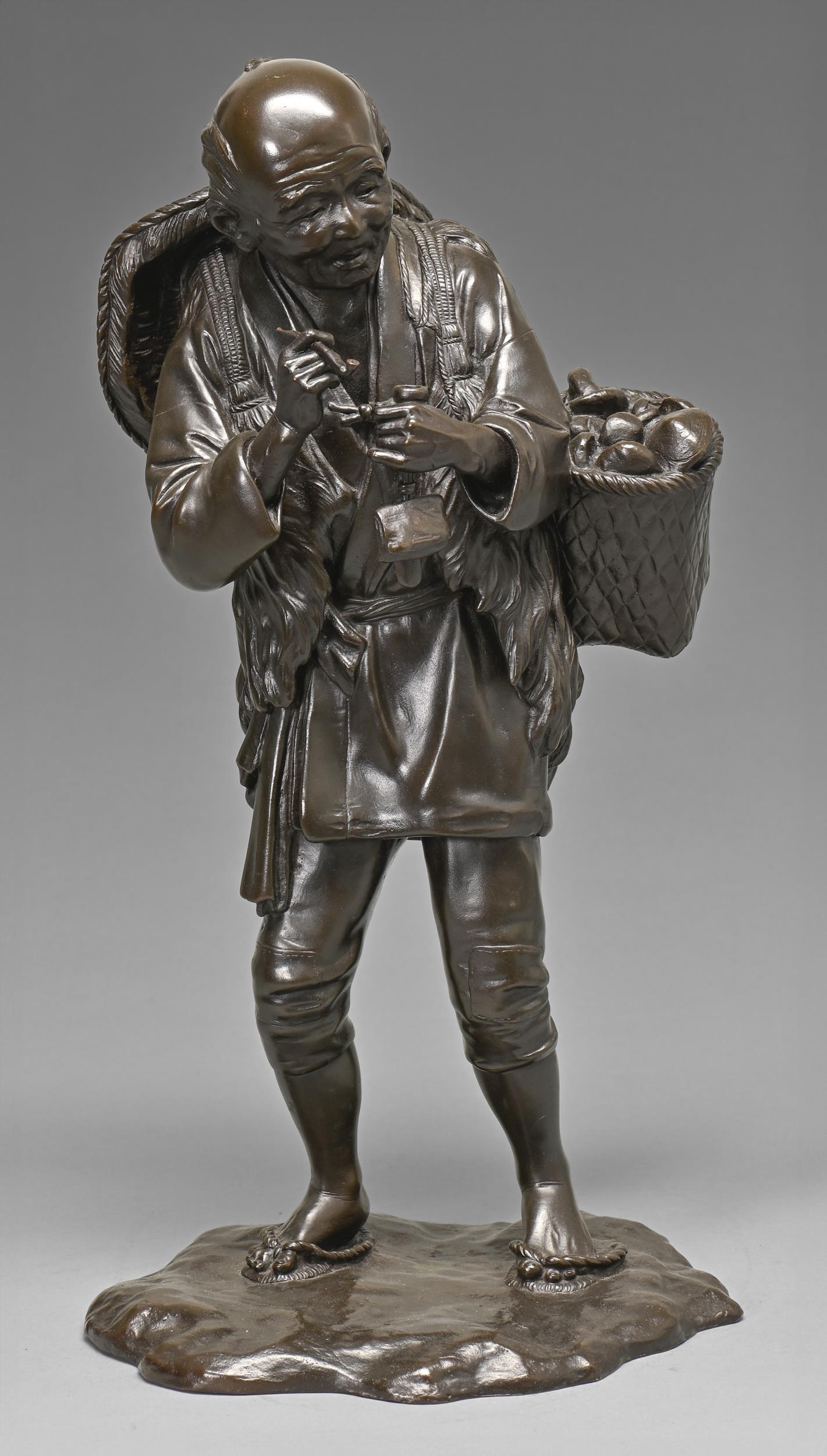 A Japanese bronze sculpture of a farmer, Meiji period, pausing to light his pipe and carrying a