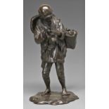 A Japanese bronze sculpture of a farmer, Meiji period, pausing to light his pipe and carrying a