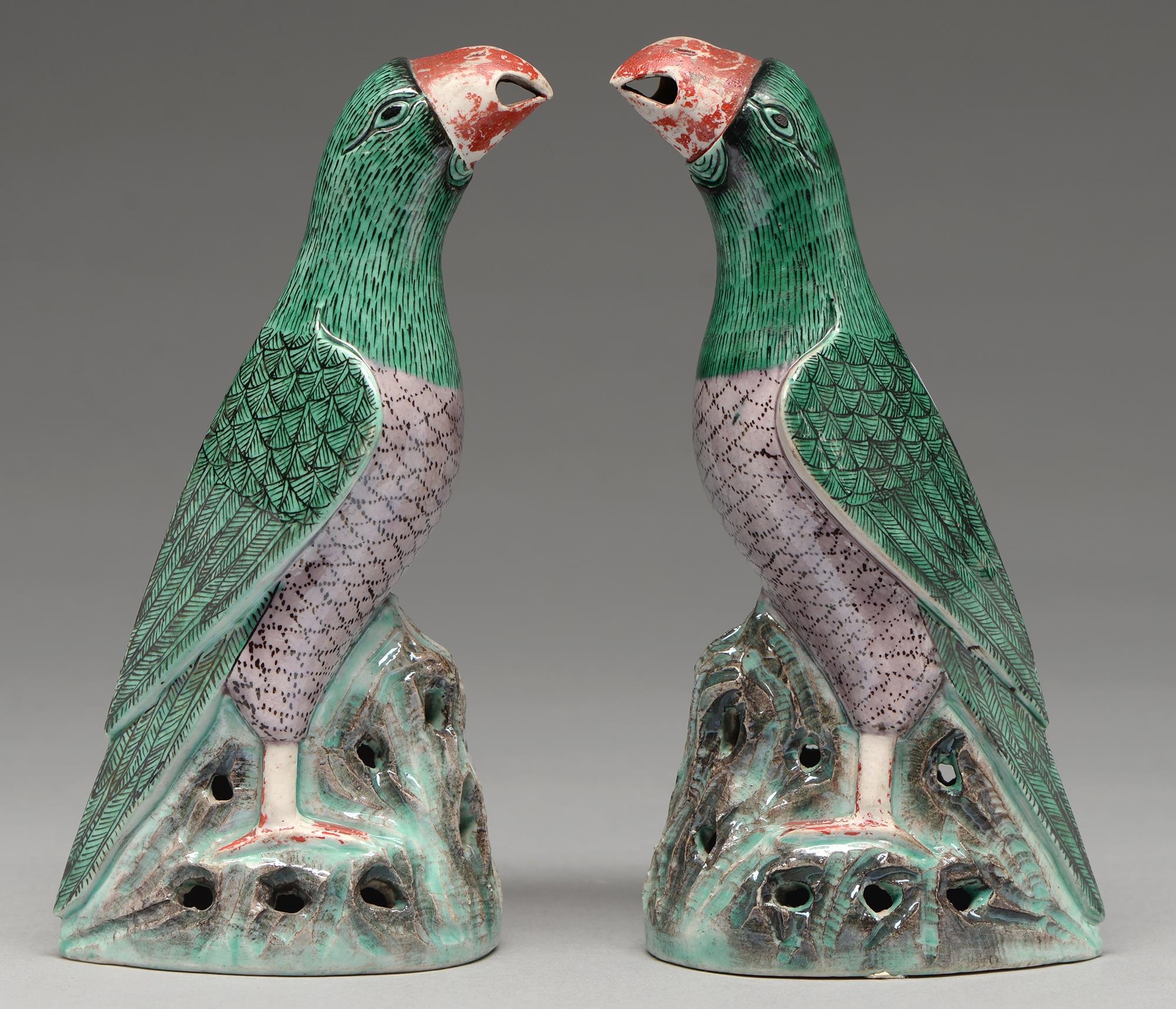 A pair of Chinese glazed biscuit models of parrots, 19th c in Kangxi style, with black eye and green
