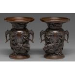 A pair of Japanese bronze dragon and phoenix vases, Meiji period, with high relief cast and