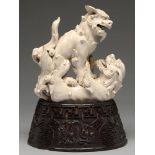 A Chinese glazed porcelain group of fighting lion dogs, 19th c or later, 28cm h, wood stand carved