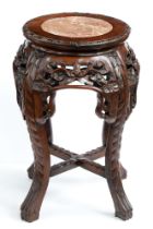 A Chinese carved hardwood  stand, c1900, with pink stone inset top and pierced floral apron, on in-