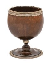An English silver mounted coconut cup, 18th c, the scalloped and reeded mount with gadrooned rim,