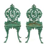 Garden furniture. A pair of Victorian cast iron chairs, the open medallion back and round seat on