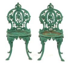 Garden furniture. A pair of Victorian cast iron chairs, the open medallion back and round seat on