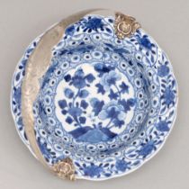 A Chinese blue and white dish, 18th c, painted to the well with two flowering plants in lotus shaped