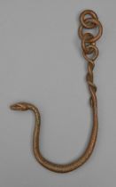 A bronze hanging sculpture of a snake entwined on a chain of three loose rings, 20th c, light