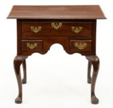 A George II oak lowboy, the one-piece, top with moulded lip and fitted with three moulded drawers