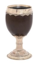 An English  silver mounted coconut cup, 18th c, with engraved scallop edged rim, on waisted stem and