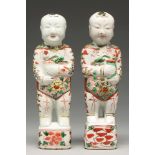 Two Chinese famille verte figures of boys, Kangxi period, holding a pot of lotus, 27.5 and 28cm h