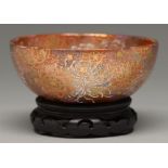 A Satsuma ware bowl, early 20th c, enamelled with chrysanthemums and peony on a firey red ground,