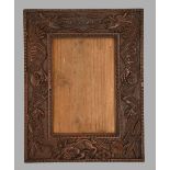 A South East Asian carved and stained wood photograph frame, c1900, with dragons, 33 x 26cm