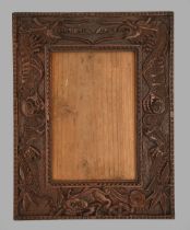 A South East Asian carved and stained wood photograph frame, c1900, with dragons, 33 x 26cm