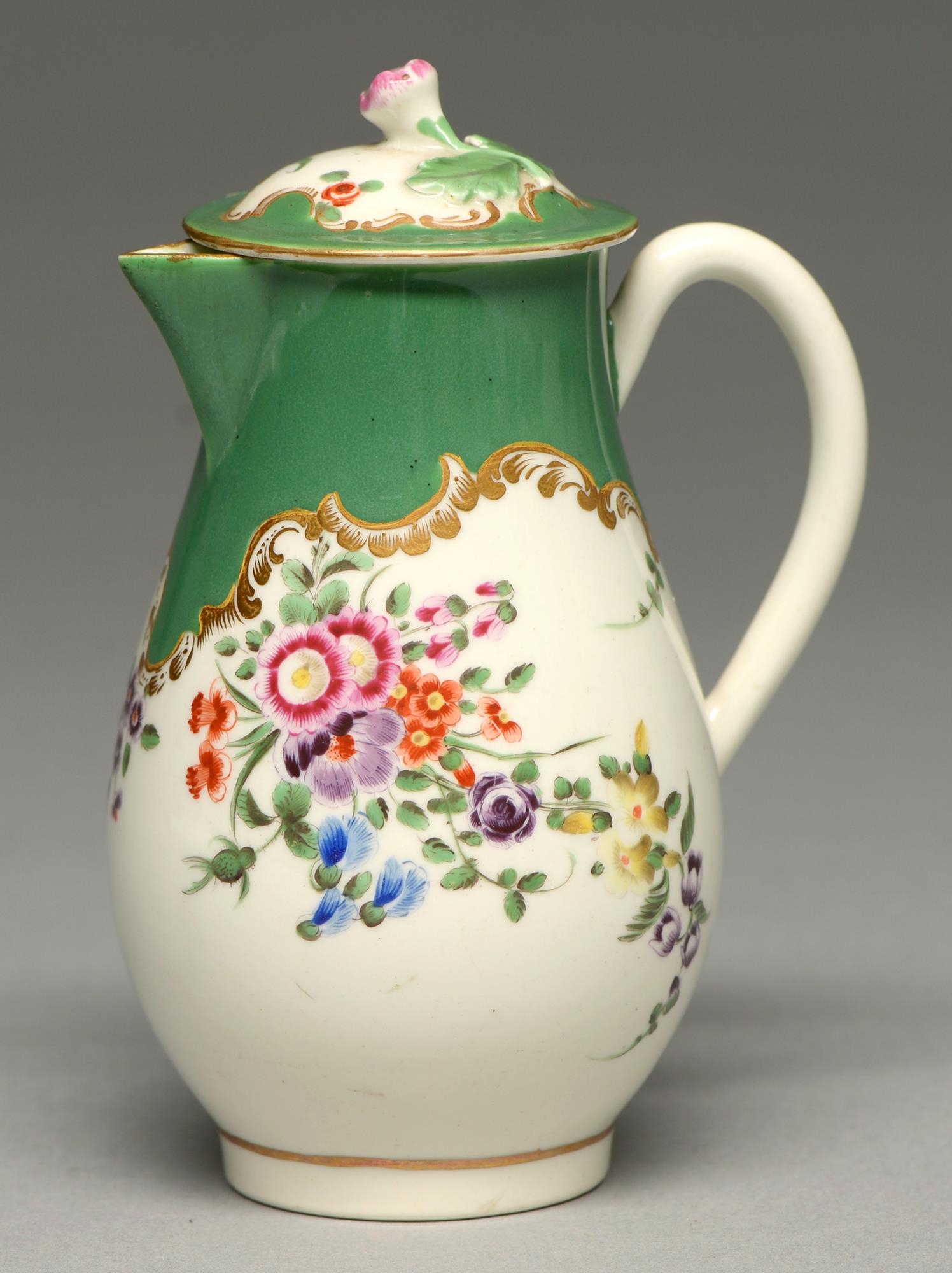A Worcester hot milk jug and cover, c1770, enamelled beneath a shaped apple green and gilt rococo