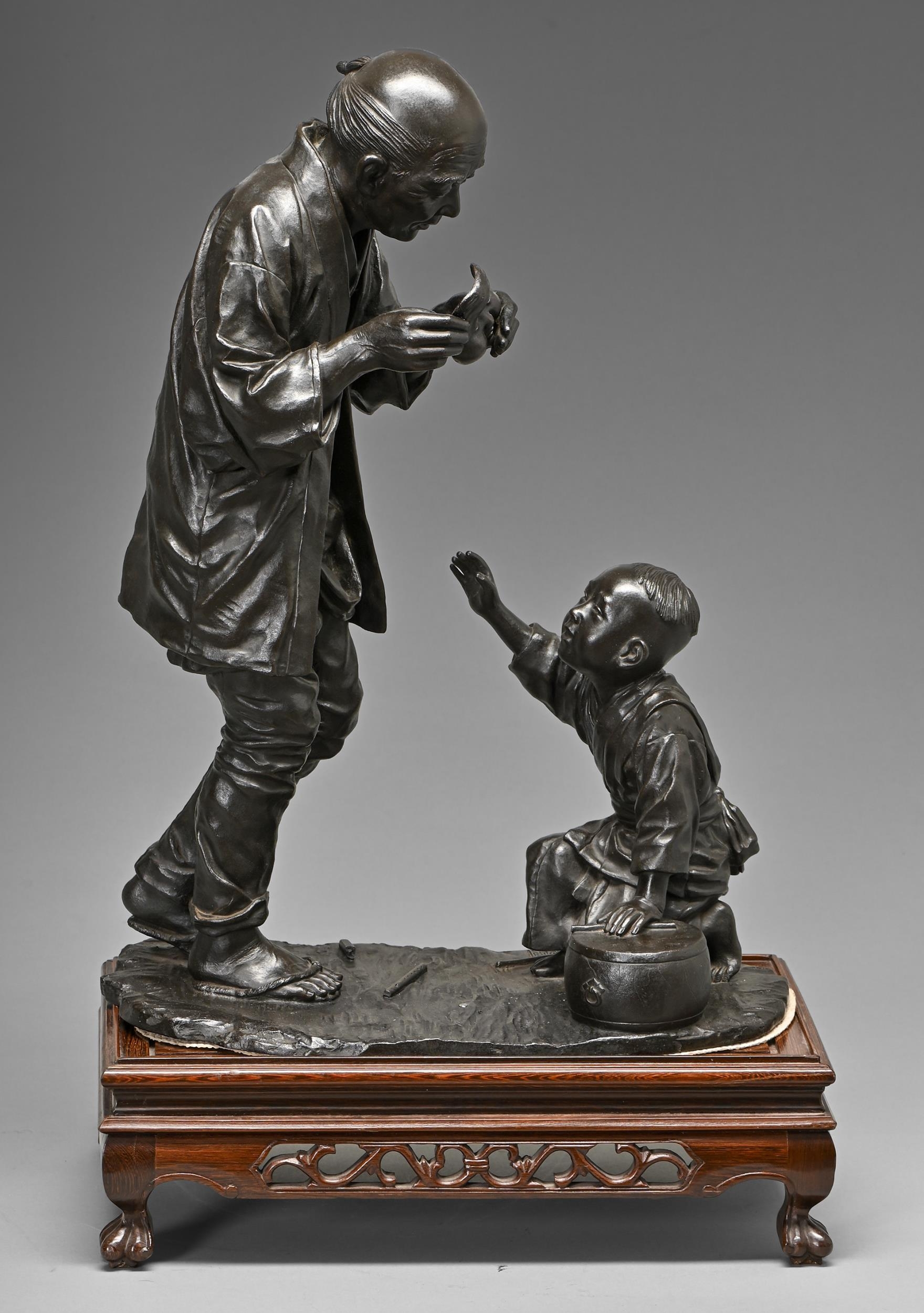 A Japanese bronze sculpture of a man and his small son with Noh mask and drum, Meiji period, even