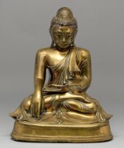 A bronze sculpture of Buddha, Burma, 19th c, with glass eyes and coloured glass detail, 38cm h