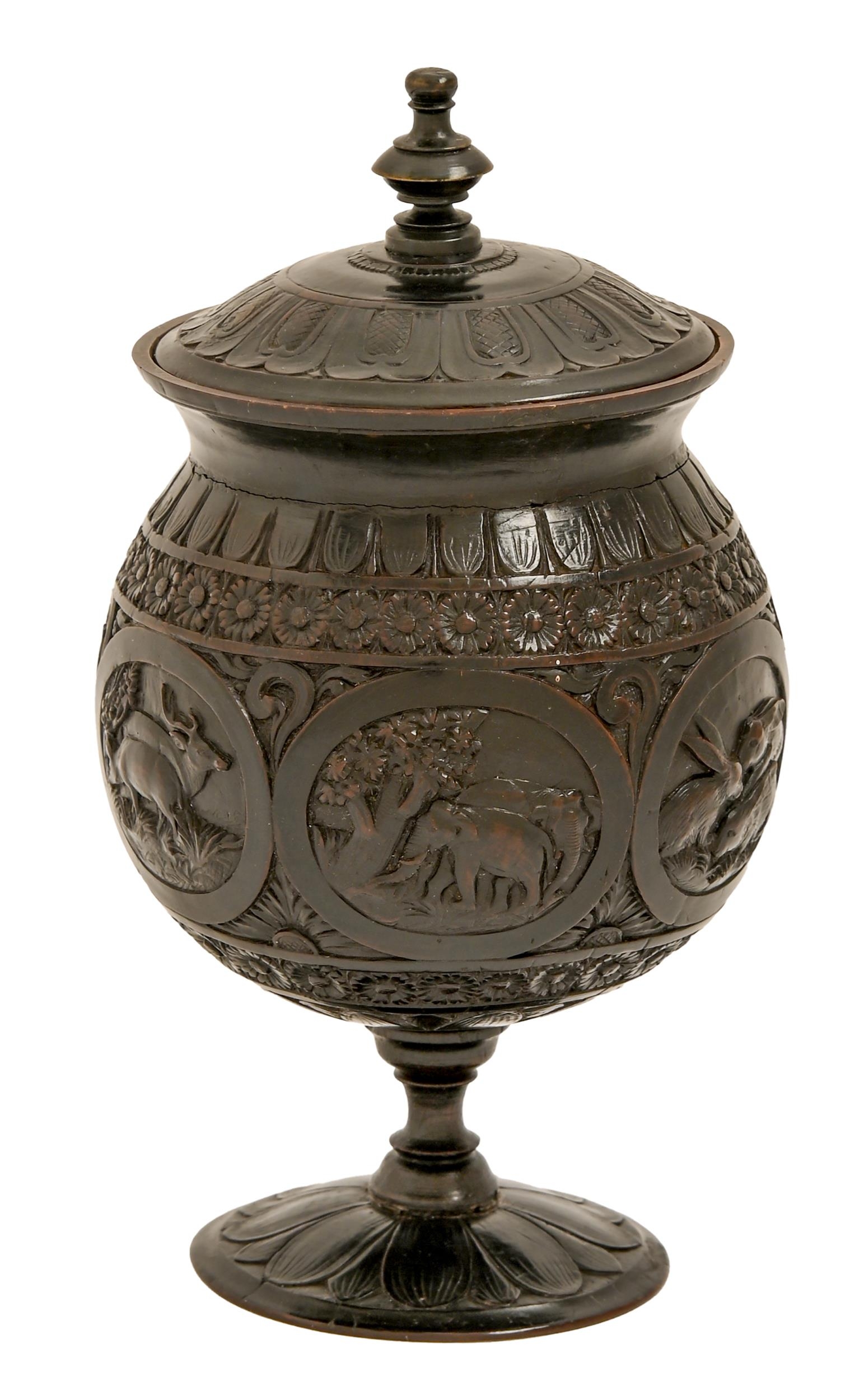 A coconut cup and cover, probably French, 19th c, carved with oval framed reserves of elephant,