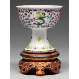 A Chinese famille rose stem cup, the bowl enamelled with dragon roundels and peonies on a pink