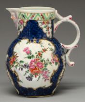 A Worcester scale blue ground cabbage leaf mask jug, c1770, painted in bright enamels with