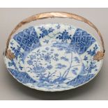 A Chinese blue and white dish, Kangxi period, painted with peony and bamboo sprouting from hollow