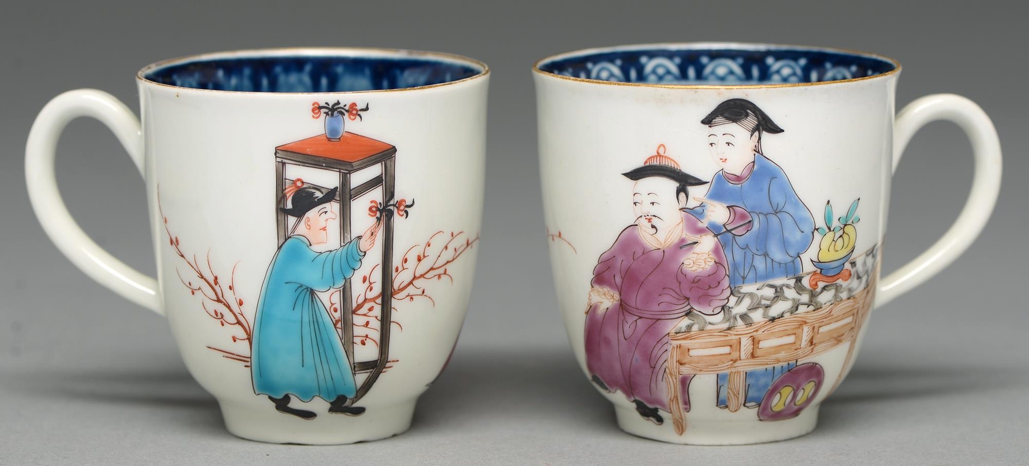 Two Worcester coffee cups, c1765, with underglaze blue border and painted with three Chinese