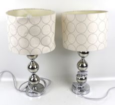 A pair of contemporary chrome bobbin like table lamps.