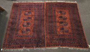 A pair of red ground woollen rugs.