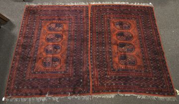 A pair of red ground woollen rugs.