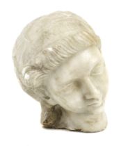 A possibly antique carved marble head of a woman wearing a headdress,