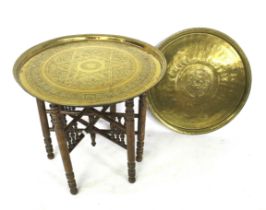 A brass charger and a foldable tray top table.
