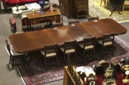 A large ten-twelve seat Regency mahogany extending twin pedestal dining table.