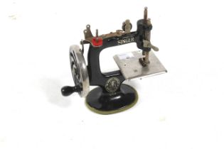 Singer : A child's toy sewing machine with black livery. Hand cranked, marked number '5' to lid, 16.
