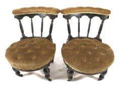 A pair of button back upholstered Victorian ebonised nursing chairs.