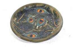 A 20th century Moorcroft four peacock feather pattern plate. Initialed 'JH. Date 96', diameter 26cm.