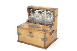 A late Victorian oak cased three-bottle tantalus and games box.