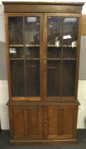 A circa 1900 two part glazed top oak bookcase converted to a display case The upper section with a