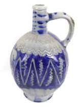 A vintage German pottery jug bottle. With blue glaze and sgraffito decoration.