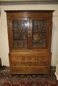 A Georgian two section astral glazed oak display cabinet.
