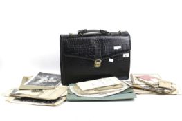 A black briefcase containing an assortment of ephemera.